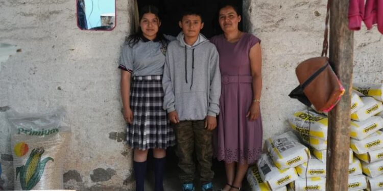 Mirsy Maricela Alva López, a la derecha, y sus hijos, Ederson, en el centro, y Briseidy posan para fotos en su casa en San Martín Cuchumatán, Guatemala, el jueves 30 de abril de 2026. (AP Foto/Moisés Castillo)