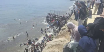 Miles de migrantes entran en Ceuta a pie por el espigón fronterizo